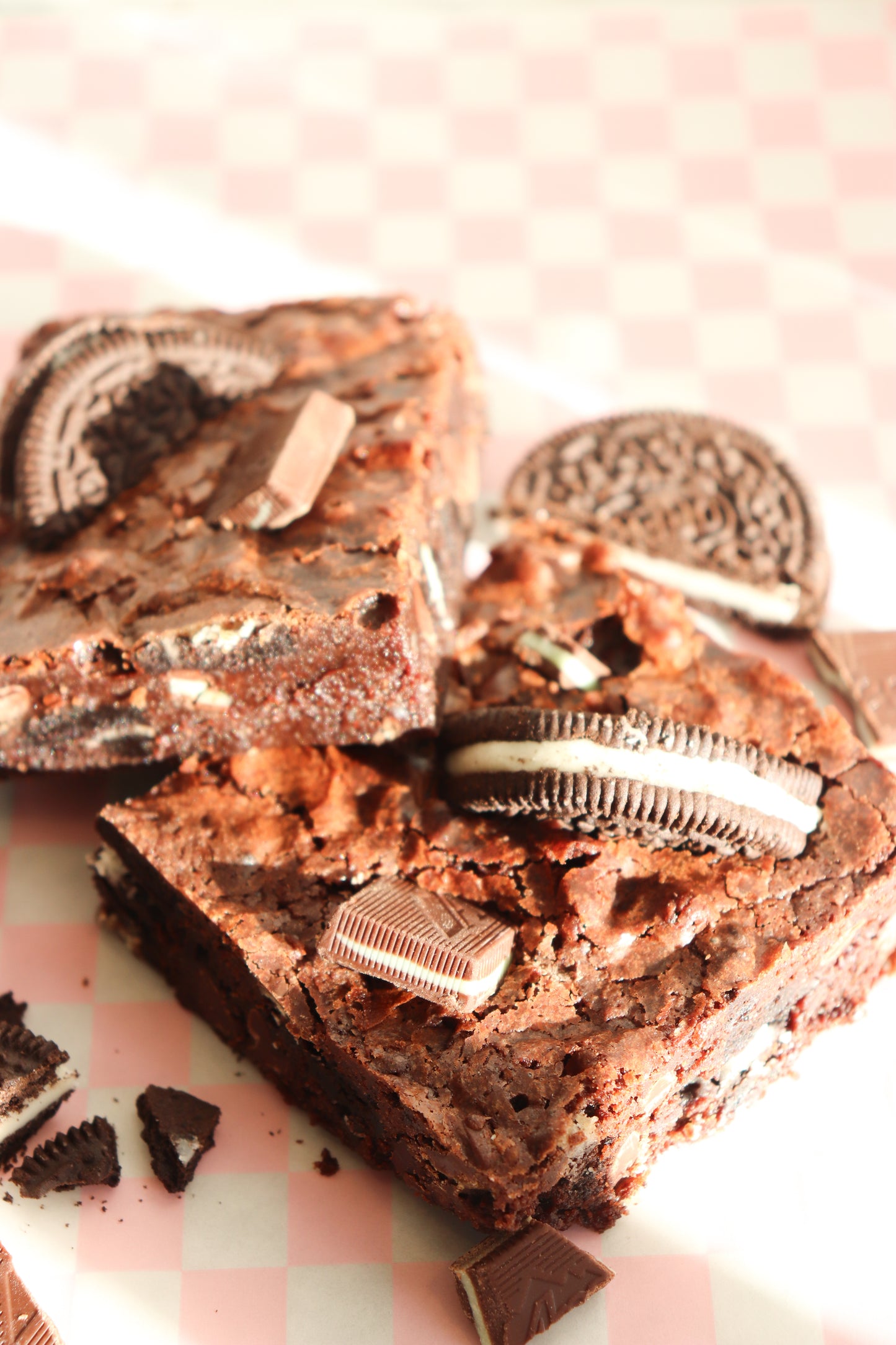 Chocolate brownies with Oreo cookies on a pink checkered background